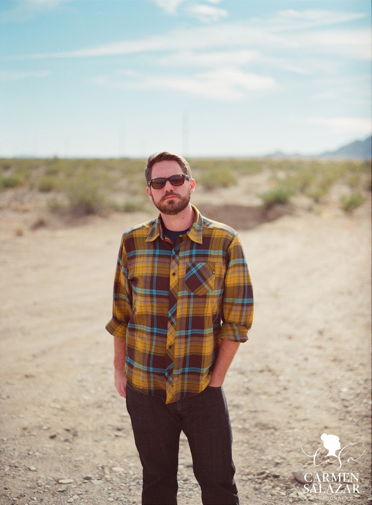 portrait of bearded man in flannel shirt in the desert by Carmen Salazar Photography