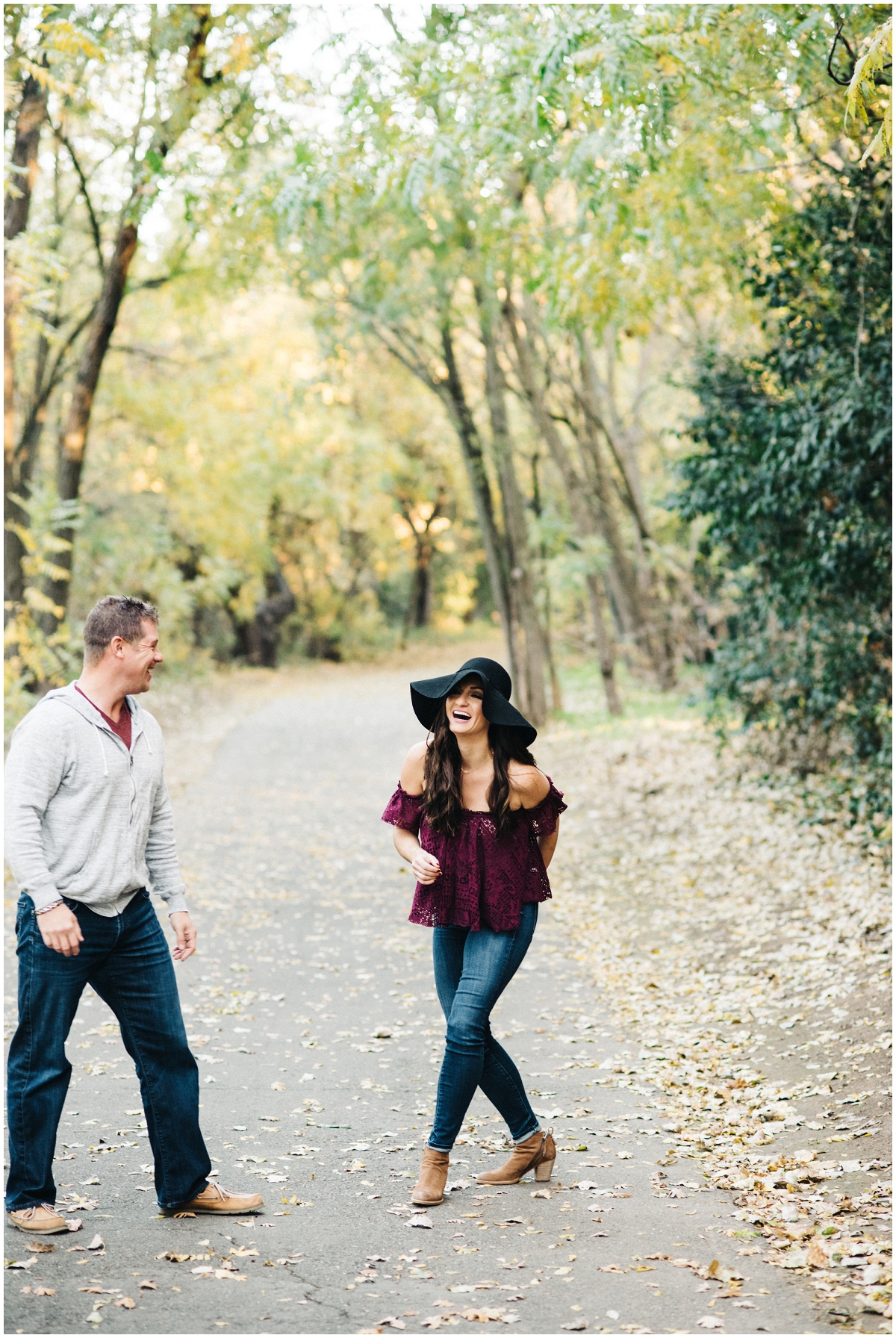 fall engagement photo of couple laughing on American River trail