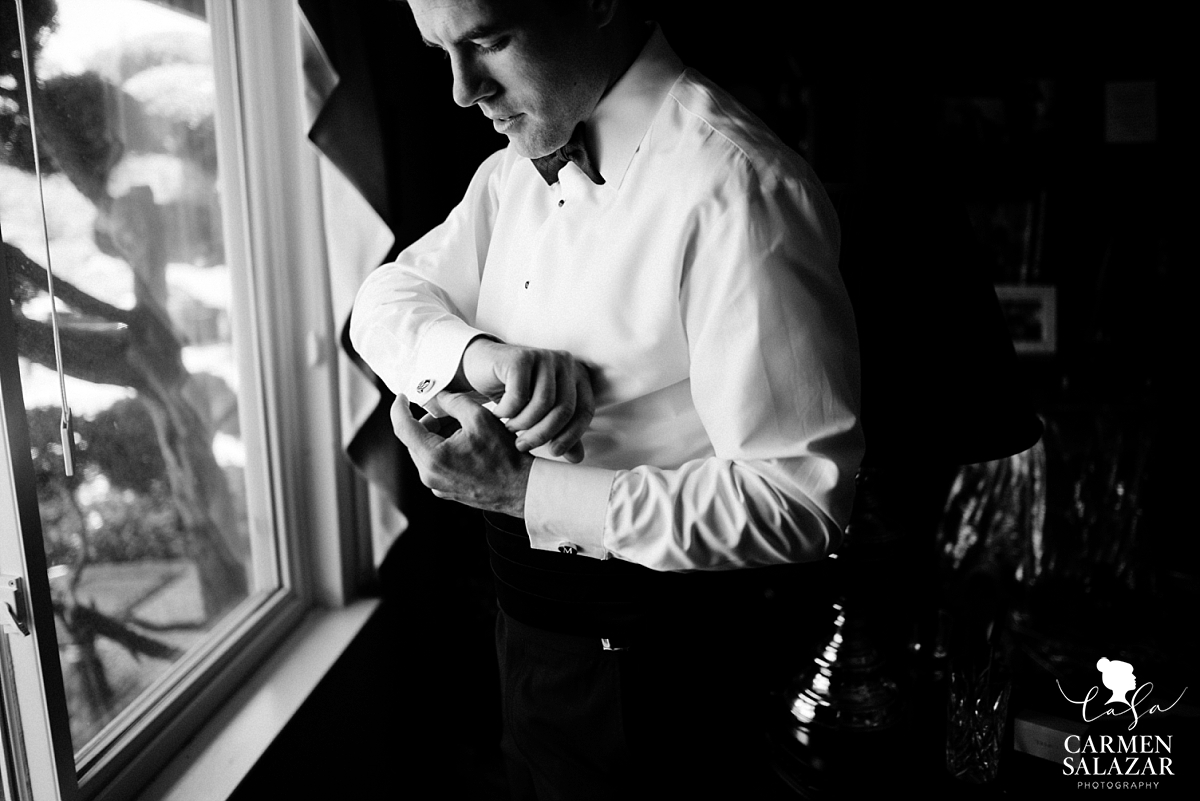 Dashing groom putting on cufflinks - Carmen Salazar