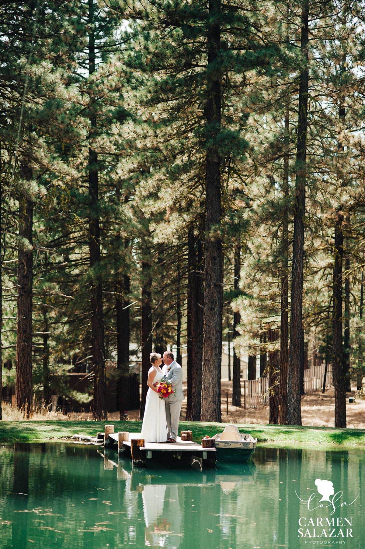 Bride and groom on dock at a pond - Carmen Salazar