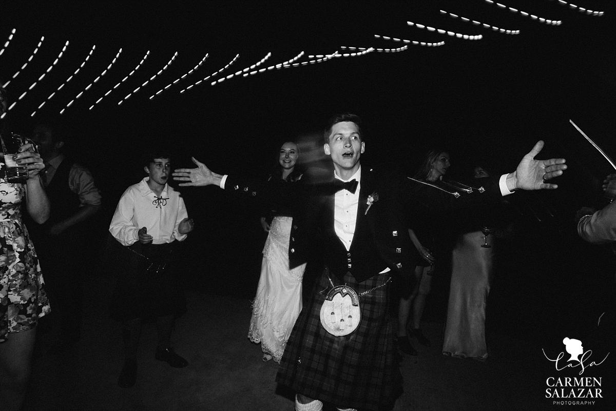 Groom doing a silly dance at outdoor reception - Carmen Salazar