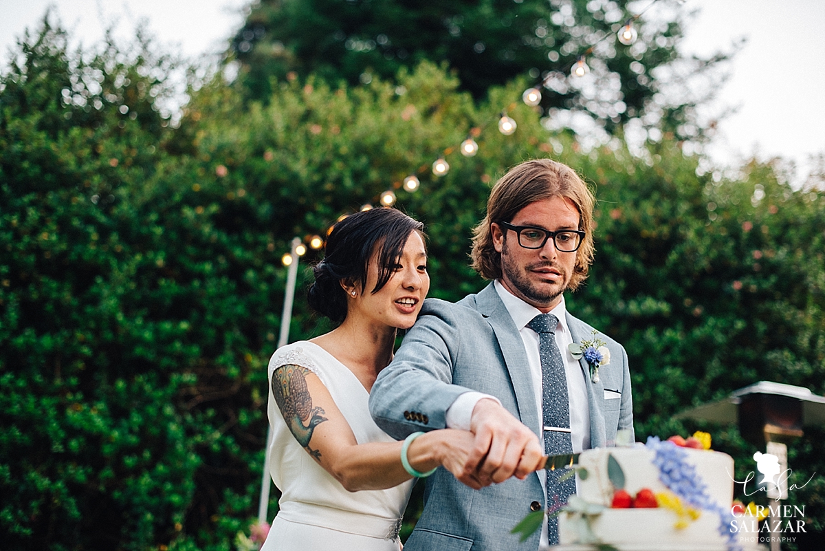 nervous Groom making silly face while cutting cake - Carmen Salazar