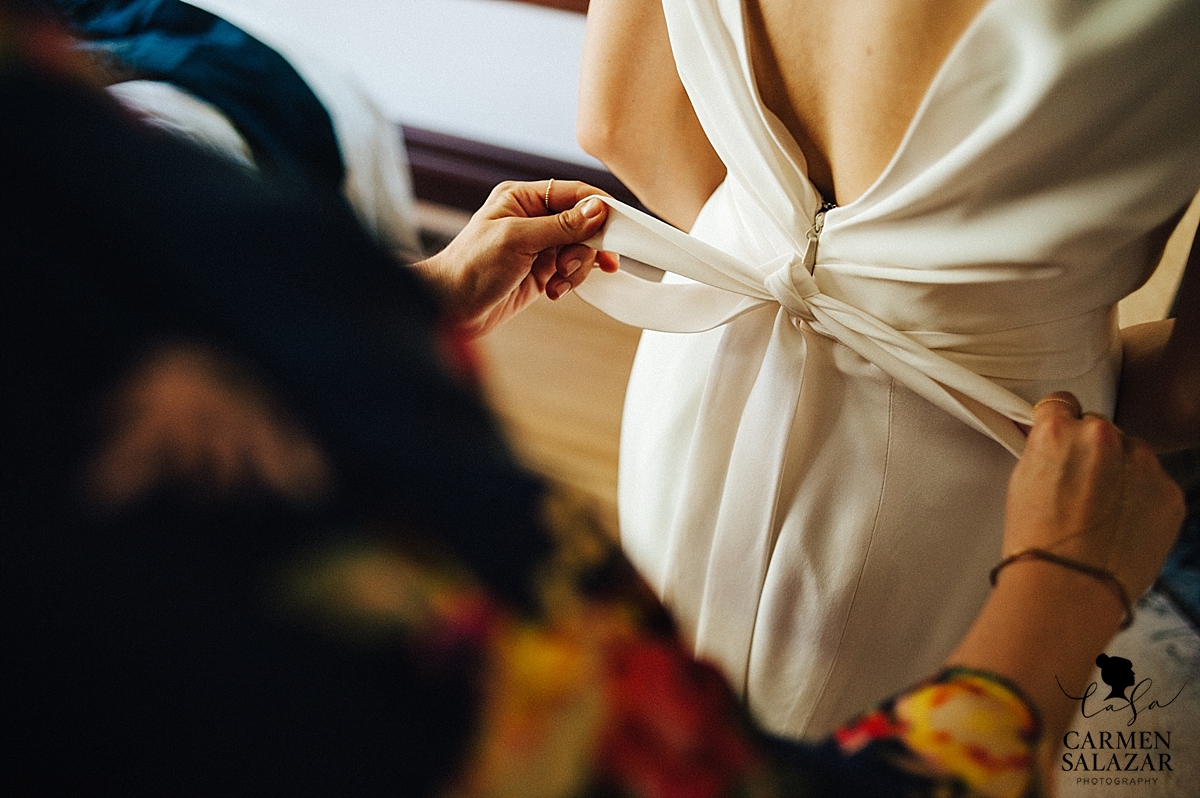 Tying the bride's bow before the ceremony - Carmen Salazar