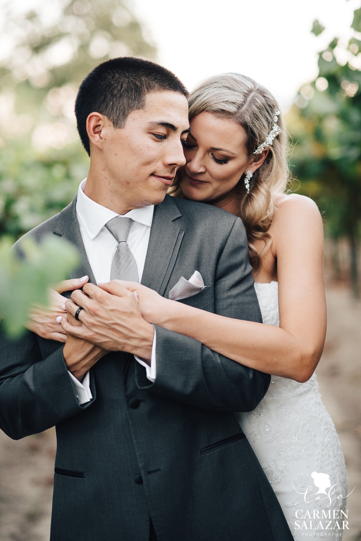 Bride and groom steal an embrace at vineyard wedding - Carmen Salazar