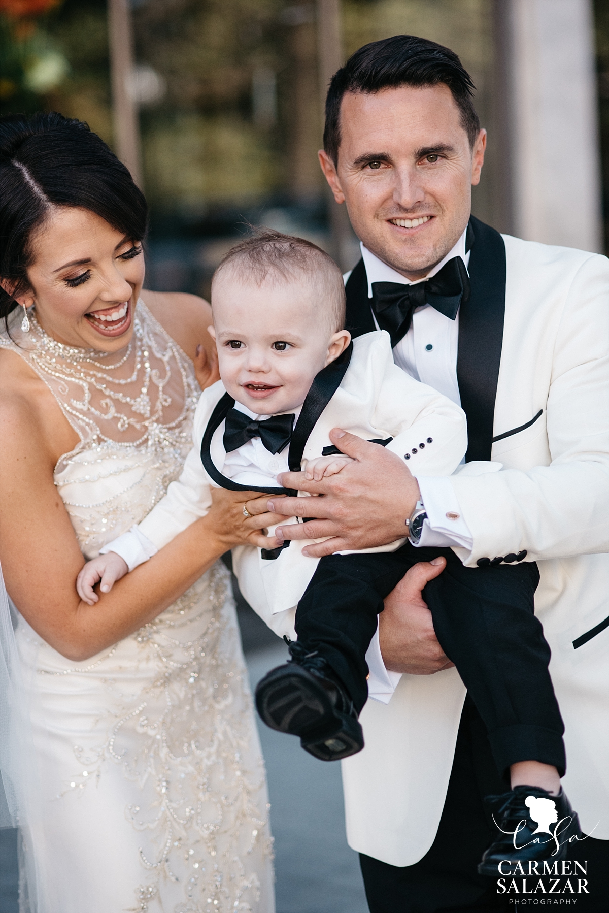 Bride and groom celebrating with baby before ceremony - Carmen Salazar