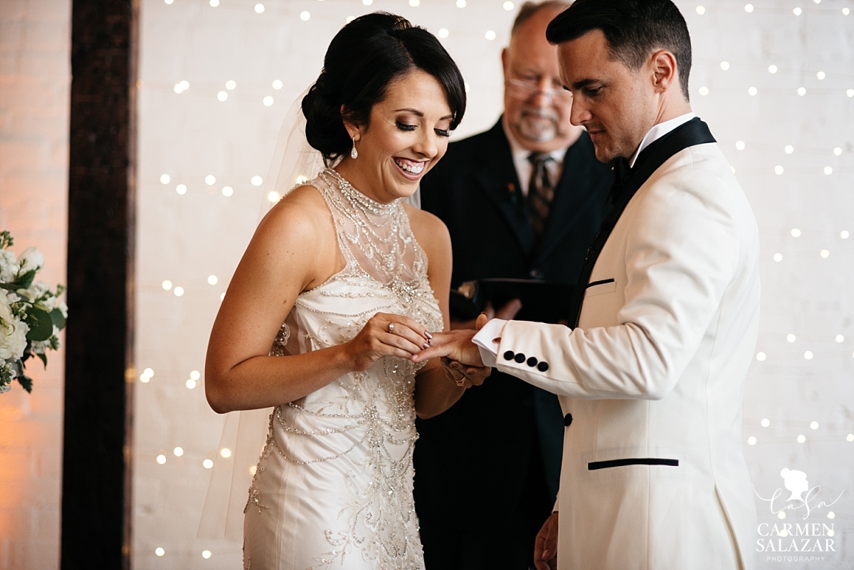 Bride putting ring on groom's finger at The Find - Carmen Salazar