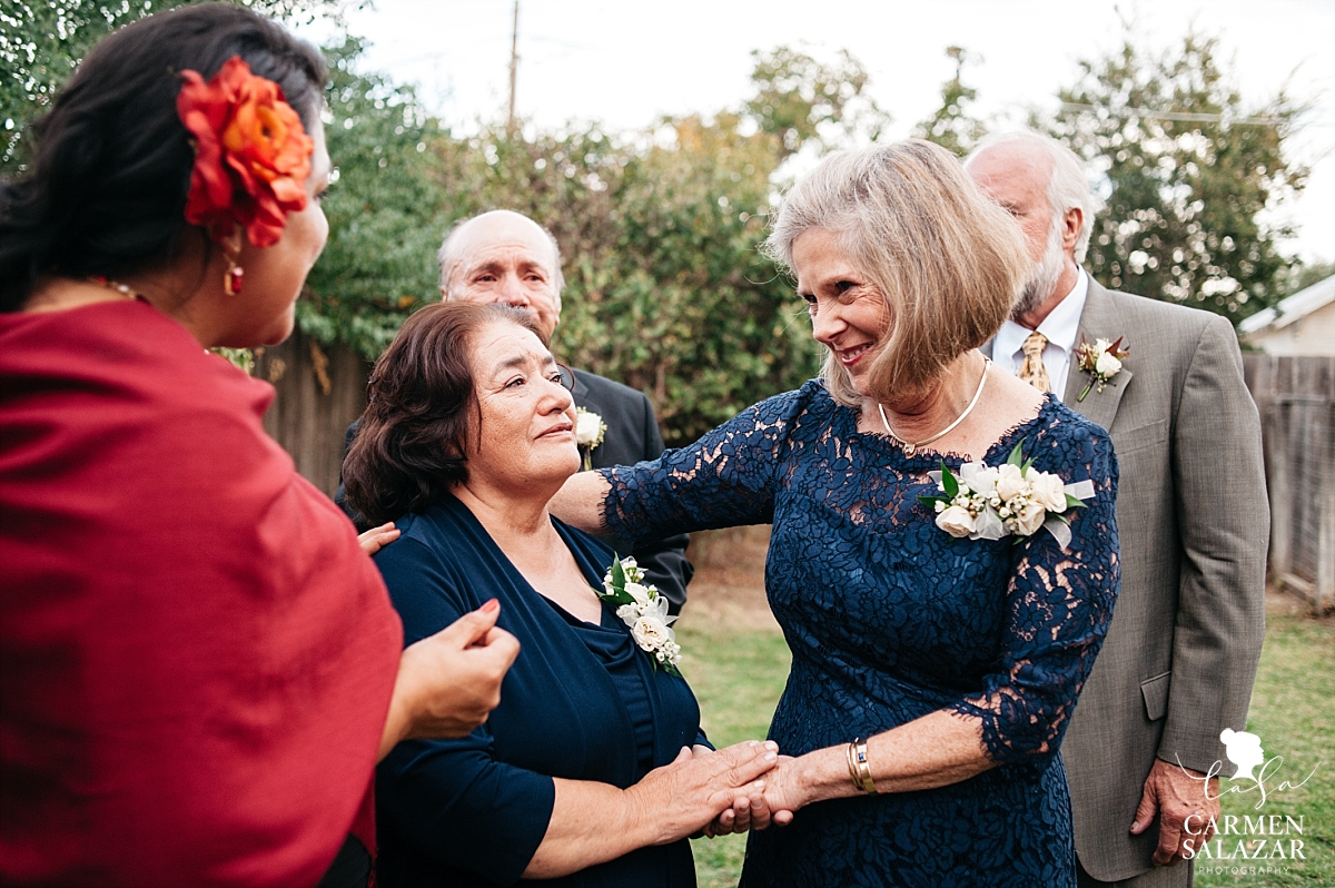 In-laws embracing after backyard wedding ceremony - Carmen Salazar