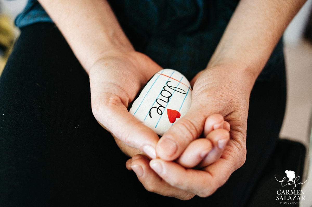 Bride holding love painted stone - Carmen Salazar