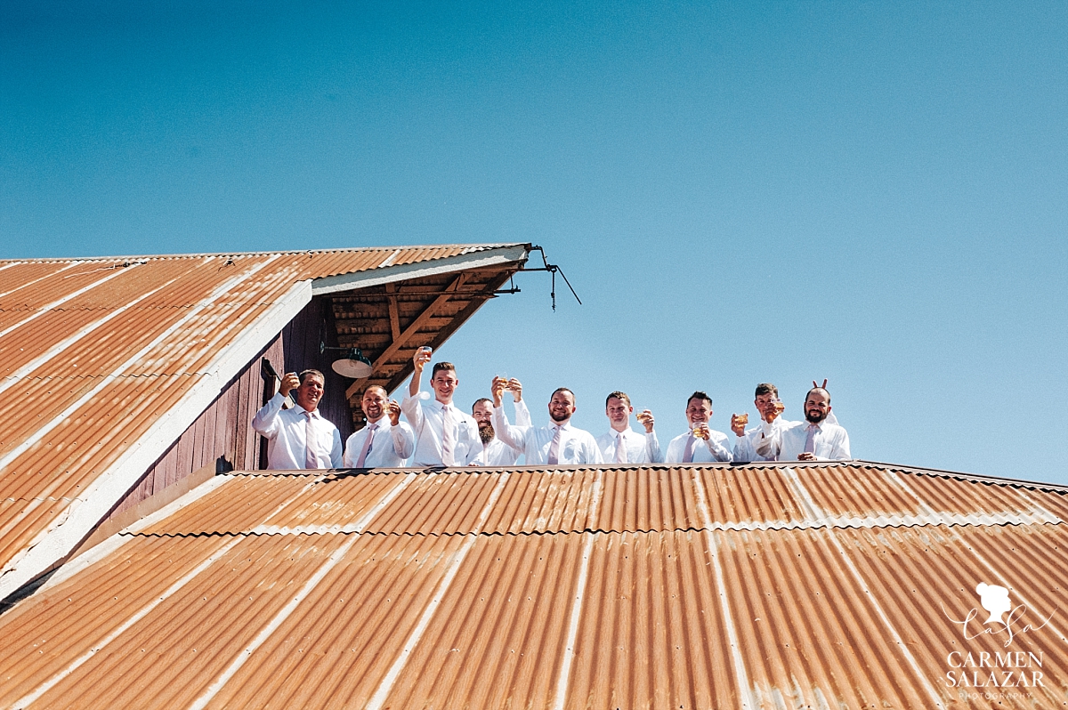 Groomsmen toasting on vintage barn roof - Carmen Salazar 