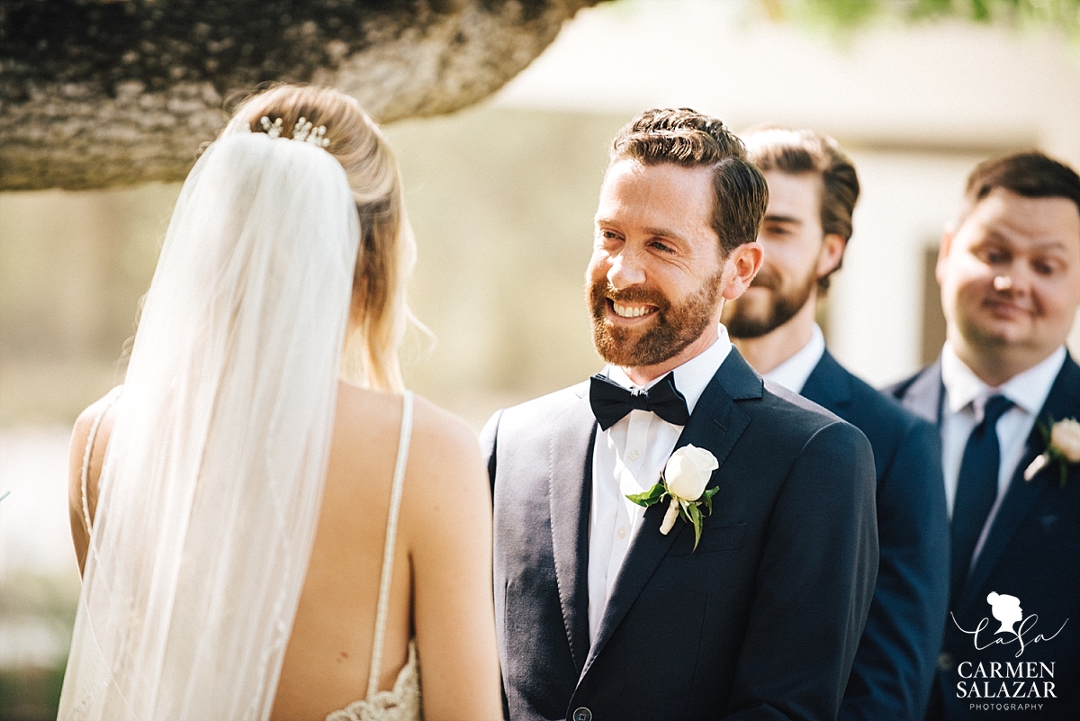 Groom looking lovingly at his bride during vows - Carmen Salazar