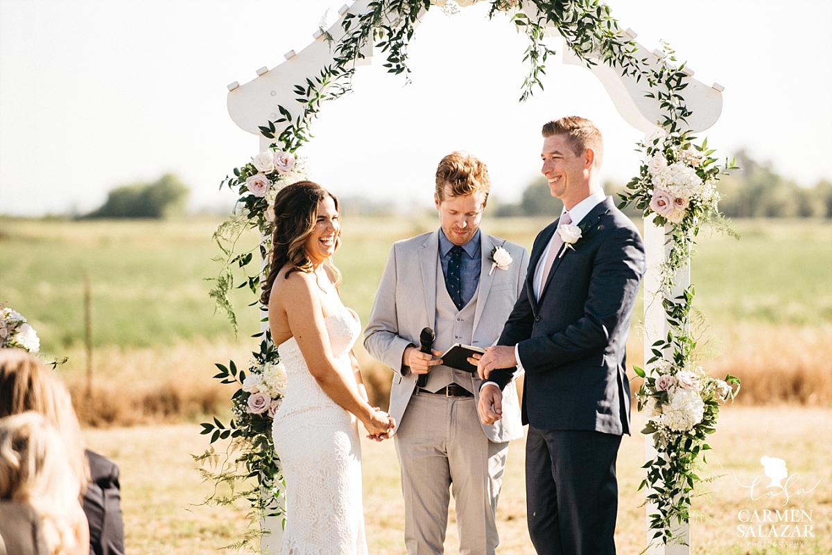 Giggling bride and groom at outdoor ceremony - Carmen Salazar 