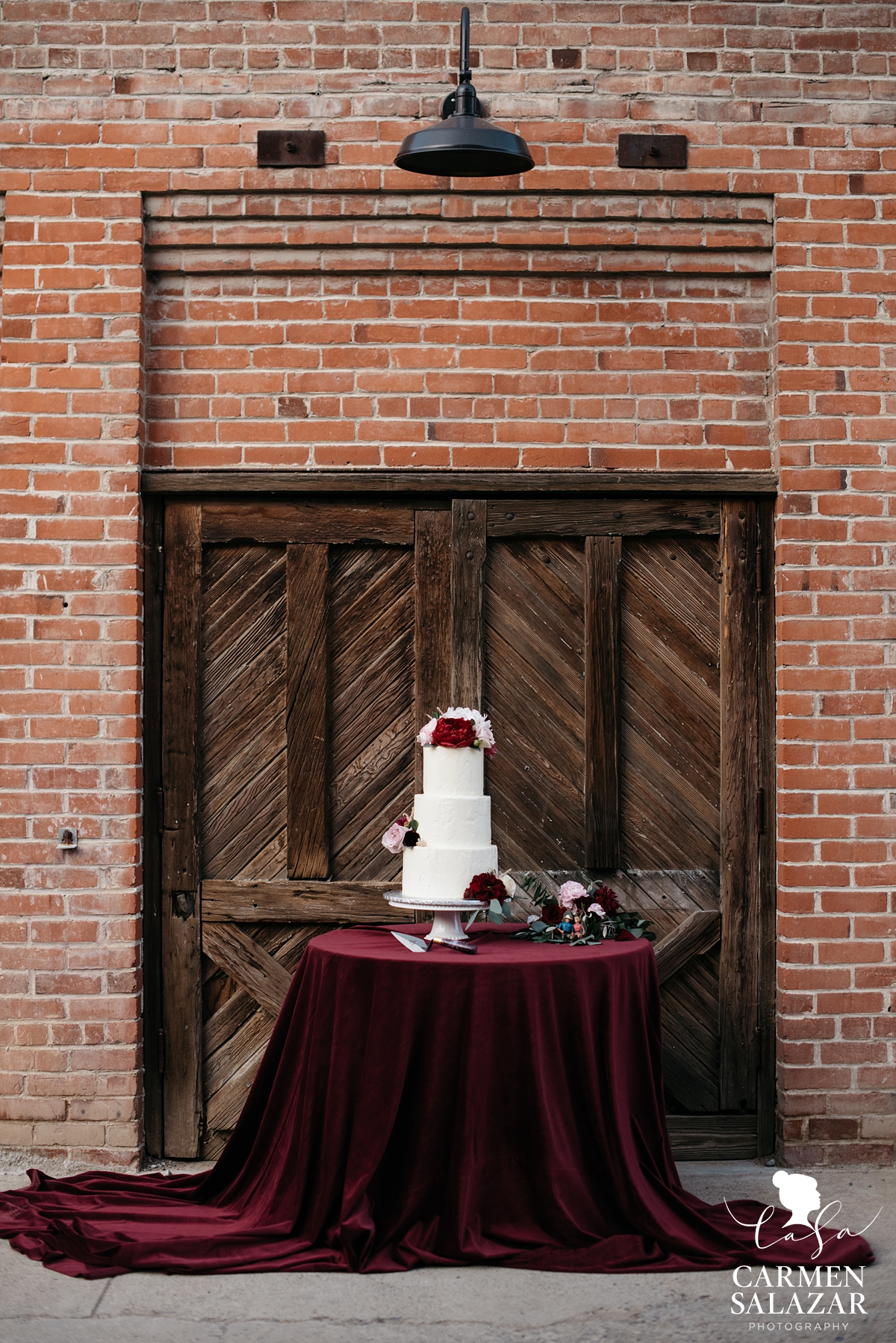three tiered white wedding cake with red velvet linen by Sacramento Wedding Photographer Carmen Salazar