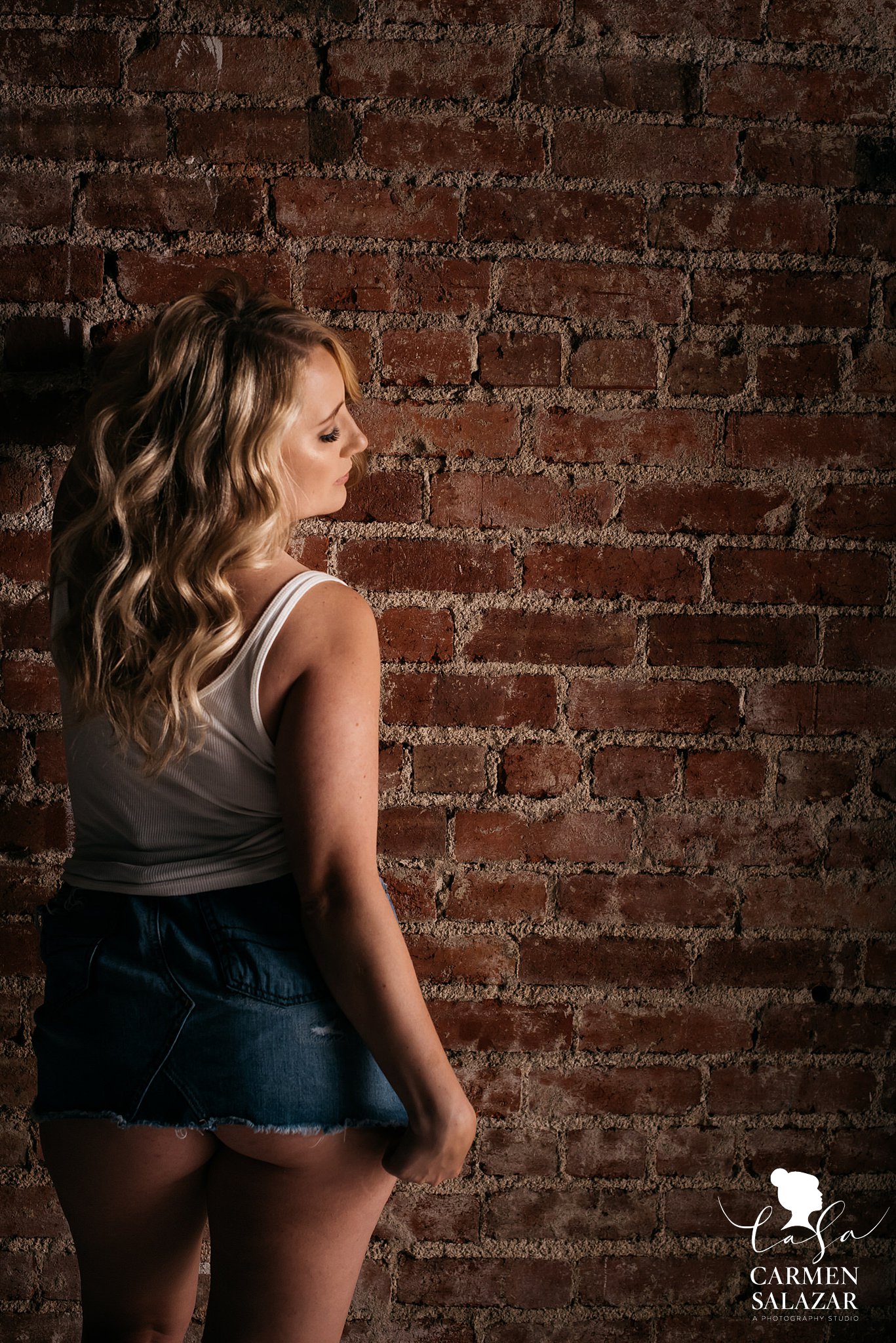 teasing boudoir pose with girl in denim skirt